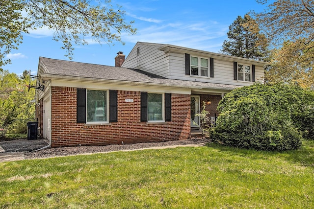 view of front of property featuring a front yard, a chimney, brick siding, and a shingled roof
