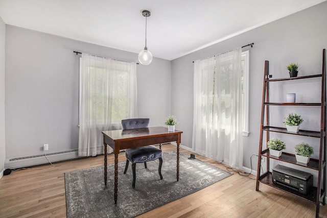 office space with light wood-type flooring and baseboards