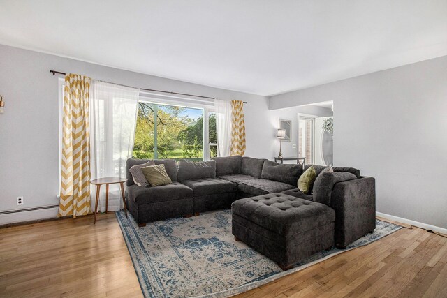 living room featuring wood finished floors, baseboards, and baseboard heating