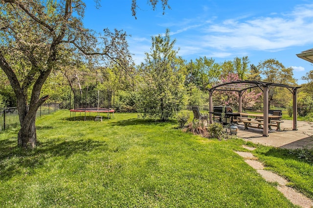 view of yard featuring a trampoline, a pergola, and a patio area