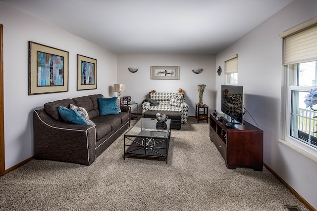 living room featuring carpet, visible vents, and baseboards