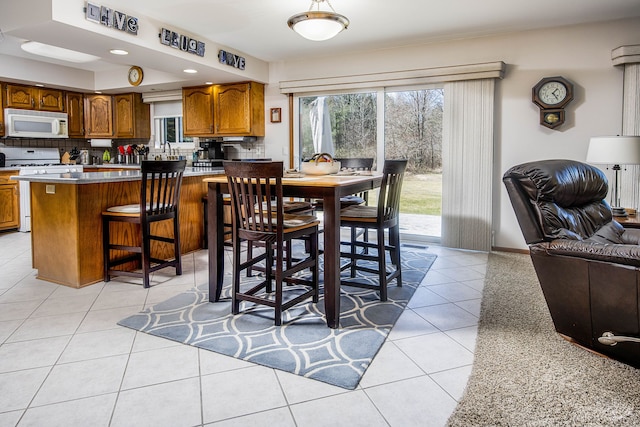 dining space featuring recessed lighting, baseboards, and light tile patterned floors