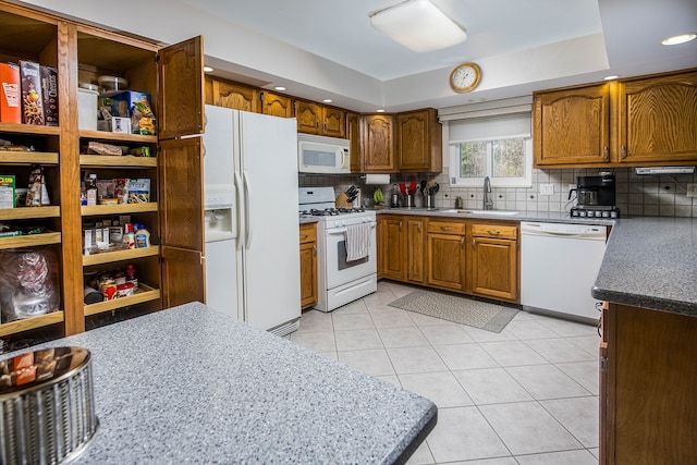 kitchen featuring decorative backsplash, white appliances, brown cabinets, and light tile patterned flooring