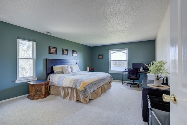 carpeted bedroom with visible vents, baseboards, and a textured ceiling