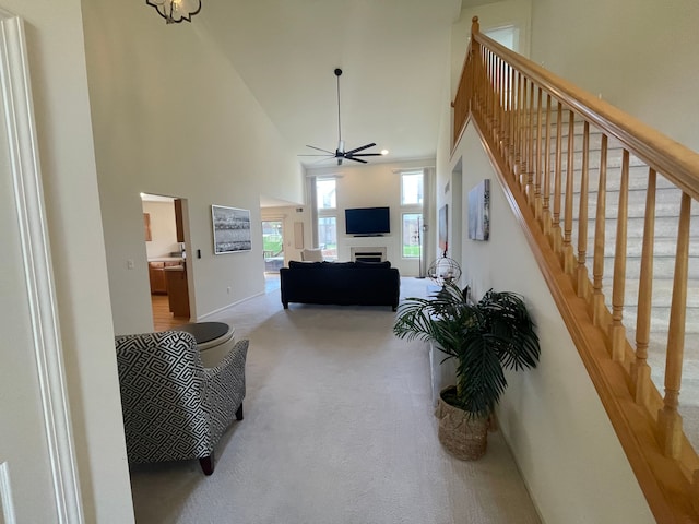6181 Warwick Dr, Commerce Twp, MI 48382 - carpeted living room with high vaulted ceiling, stairway, and a ceiling fan