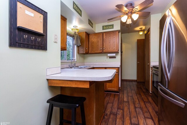 6051 Homestead Pl, Grand Blanc, MI 48439 - kitchen featuring a peninsula, a sink, light countertops, stainless steel appliances, and brown cabinets