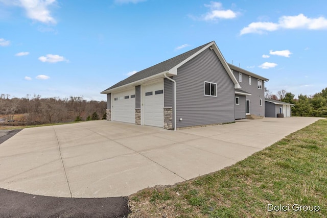 view of side of property featuring a garage and stone siding