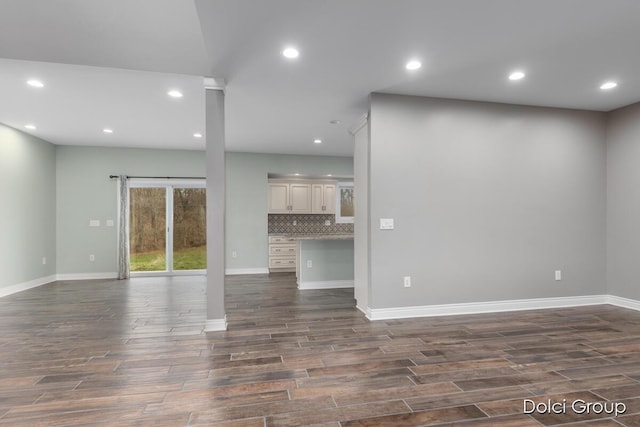 unfurnished living room with baseboards, dark wood-style floors, and recessed lighting
