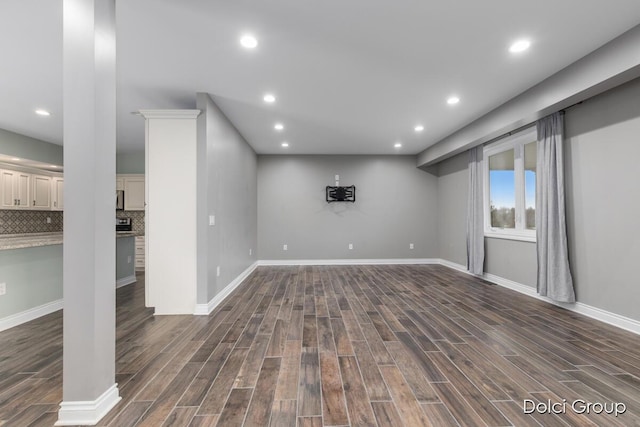 basement featuring dark wood-style flooring, baseboards, and recessed lighting