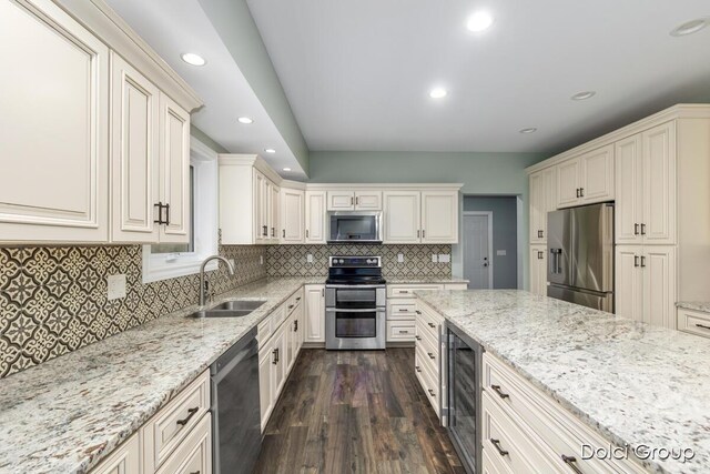 kitchen with recessed lighting, appliances with stainless steel finishes, dark wood-style flooring, a sink, and wine cooler
