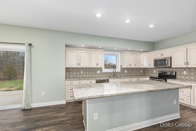 kitchen featuring tasteful backsplash, dark wood-style flooring, recessed lighting, appliances with stainless steel finishes, and a sink