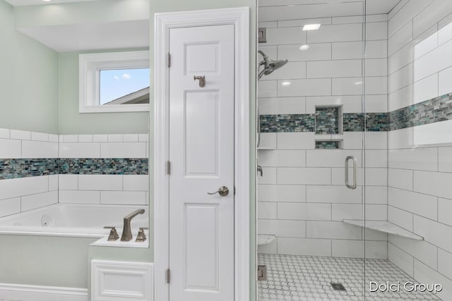 bathroom with a shower stall and a bath