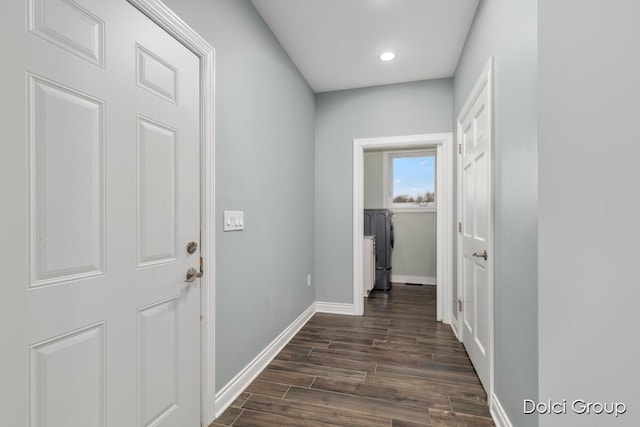 hallway featuring dark wood-type flooring, baseboards, and recessed lighting