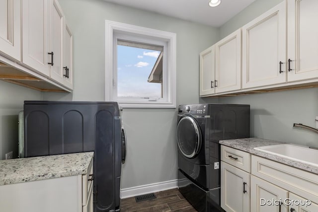 laundry room featuring cabinet space, independent washer and dryer, baseboards, and a sink