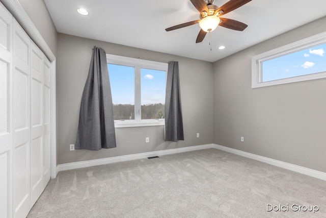 unfurnished bedroom with carpet, visible vents, a closet, and baseboards