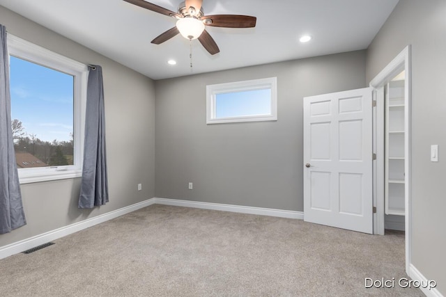 unfurnished room with ceiling fan, baseboards, visible vents, and carpet floors