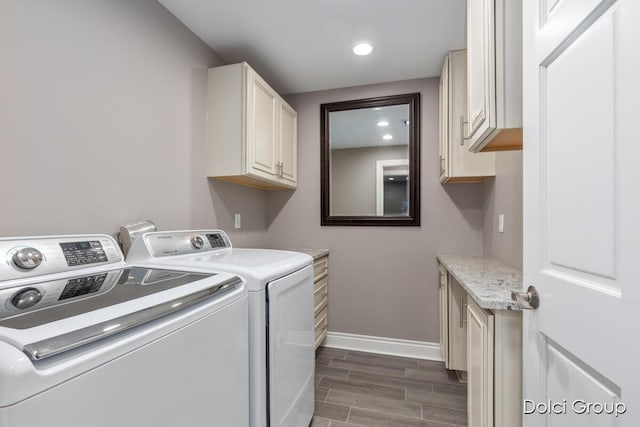 clothes washing area with separate washer and dryer, recessed lighting, wood tiled floor, baseboards, and cabinet space