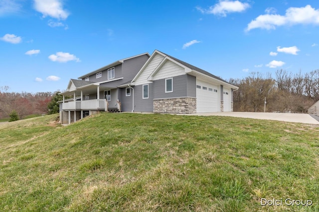 view of front facade featuring a porch, stone siding, a garage, a front lawn, and driveway