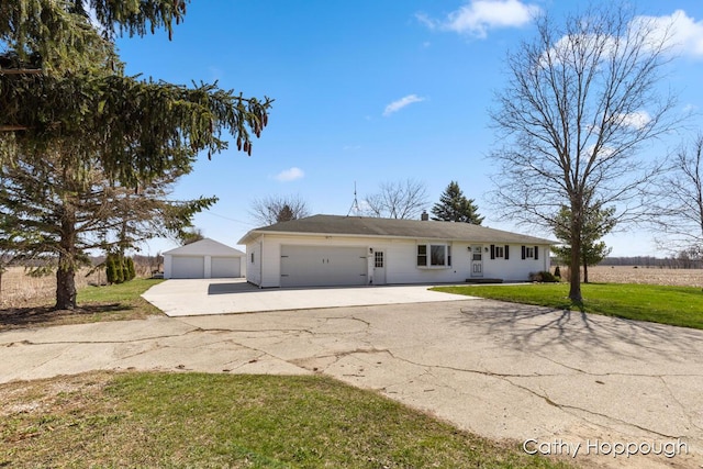 ranch-style house featuring a detached garage, concrete driveway, and a front yard