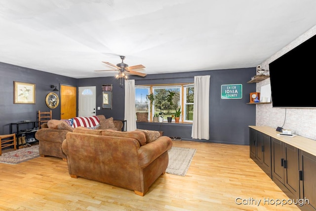 living room with a ceiling fan and light wood-style floors