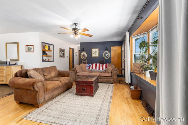 living area featuring light wood-style flooring and a ceiling fan