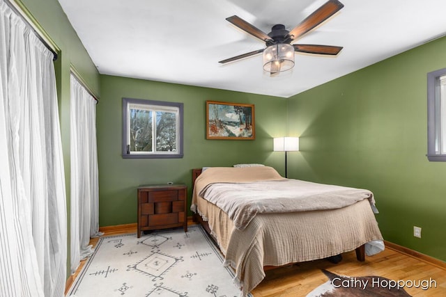 bedroom with ceiling fan, baseboards, and wood finished floors