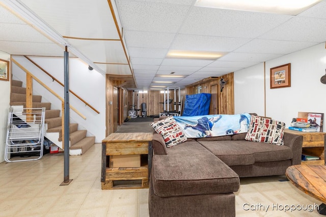 living room featuring stairway and a drop ceiling