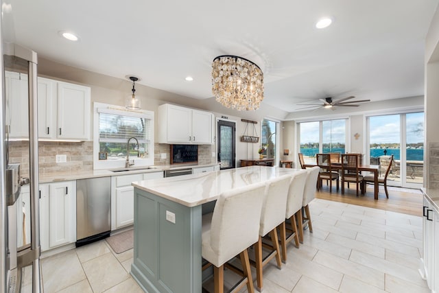 kitchen featuring a breakfast bar area, a center island, a sink, and a healthy amount of sunlight