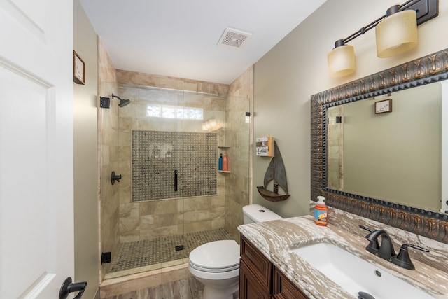 full bathroom featuring a stall shower, visible vents, vanity, and toilet
