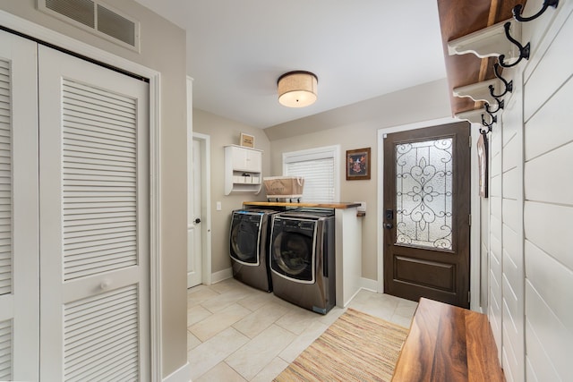 laundry area with washing machine and clothes dryer, laundry area, visible vents, and baseboards