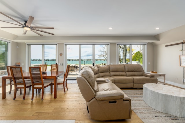 living room featuring light wood finished floors, a wealth of natural light, and a ceiling fan