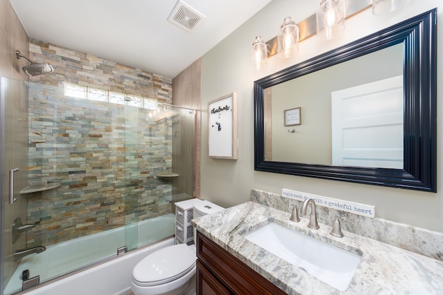 full bath featuring visible vents, vanity, bath / shower combo with glass door, and toilet