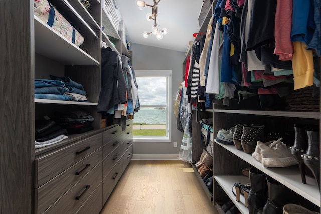 walk in closet featuring light wood-style floors and lofted ceiling