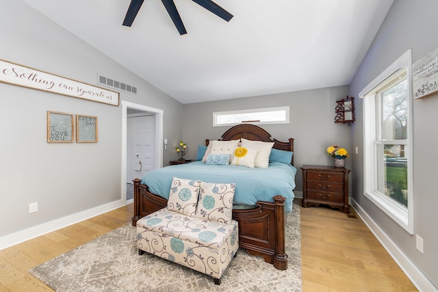 bedroom with vaulted ceiling, light wood finished floors, multiple windows, and visible vents