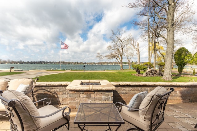 view of patio with an outdoor fire pit and a water view