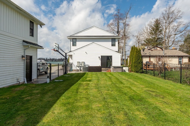 back of house featuring a gate, a yard, a fenced backyard, and a standing seam roof