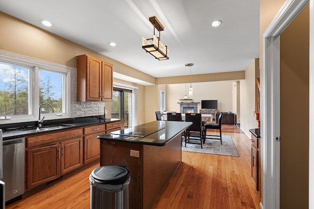 9025 Huron Bluffs Dr, White Lake, MI 48386 - kitchen with a sink, black electric cooktop, dishwasher, light wood-style floors, and a kitchen island