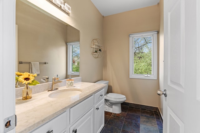 9025 Huron Bluffs Dr, White Lake, MI 48386 - bathroom with a wealth of natural light, toilet, vanity, and stone tile flooring
