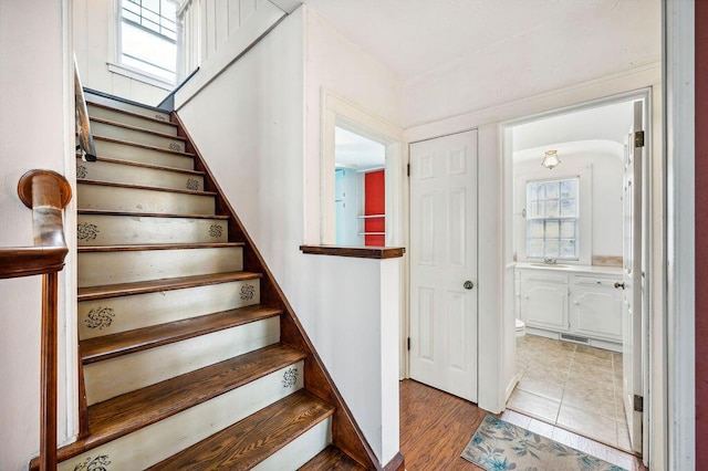 stairway featuring visible vents and wood finished floors