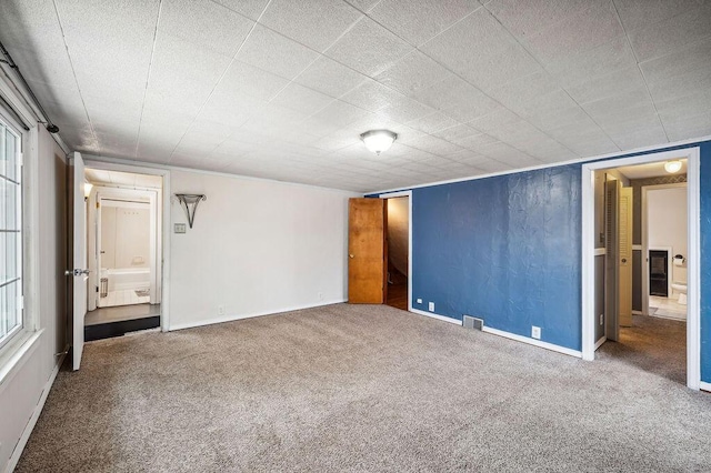 unfurnished bedroom with visible vents, baseboards, connected bathroom, and carpet