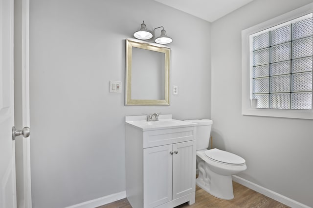 25763 Gibraltar Rd, Flat Rock, MI 48134 - bathroom featuring baseboards, vanity, toilet, and wood finished floors