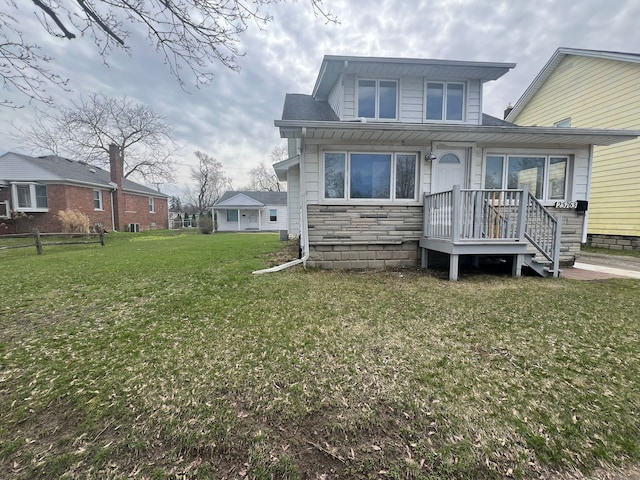 25763 Gibraltar Rd, Flat Rock, MI 48134 - back of property with a lawn, fence, and stone siding