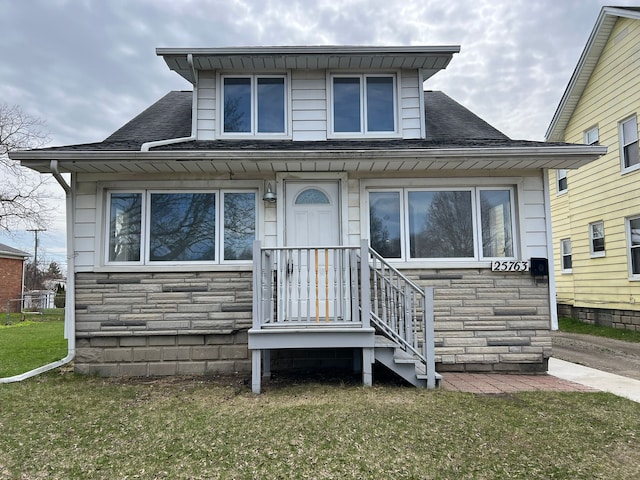 25763 Gibraltar Rd, Flat Rock, MI 48134 - bungalow-style house with a front yard, a shingled roof, and stone siding