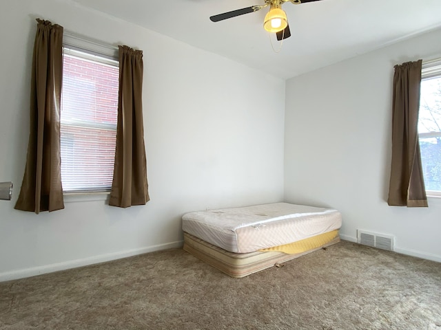 carpeted bedroom with baseboards, visible vents, and a ceiling fan