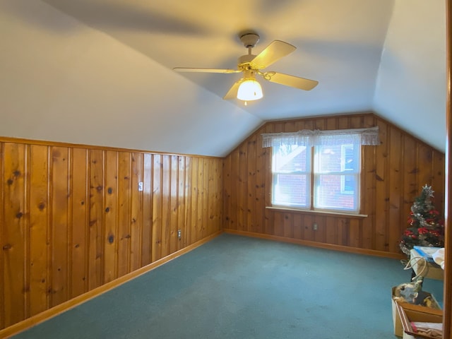 bonus room with wood walls, carpet, ceiling fan, and vaulted ceiling