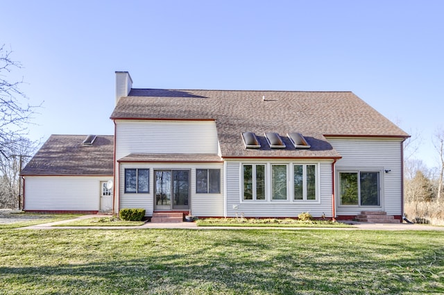 rear view of property featuring a chimney, roof with shingles, a yard, and entry steps