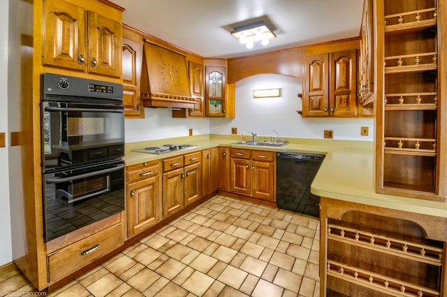 kitchen with a sink, custom exhaust hood, brown cabinetry, light countertops, and black appliances