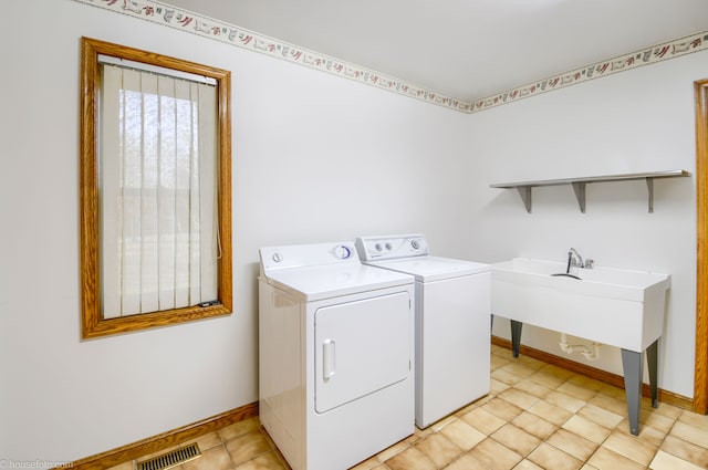 clothes washing area with baseboards, visible vents, independent washer and dryer, and laundry area