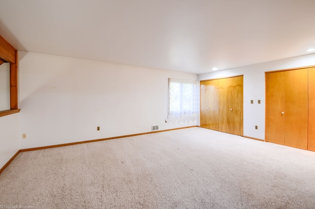 unfurnished bedroom with visible vents, baseboards, recessed lighting, two closets, and carpet floors