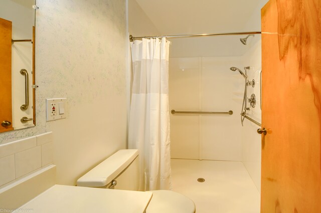 full bath with a shower with shower curtain and toilet